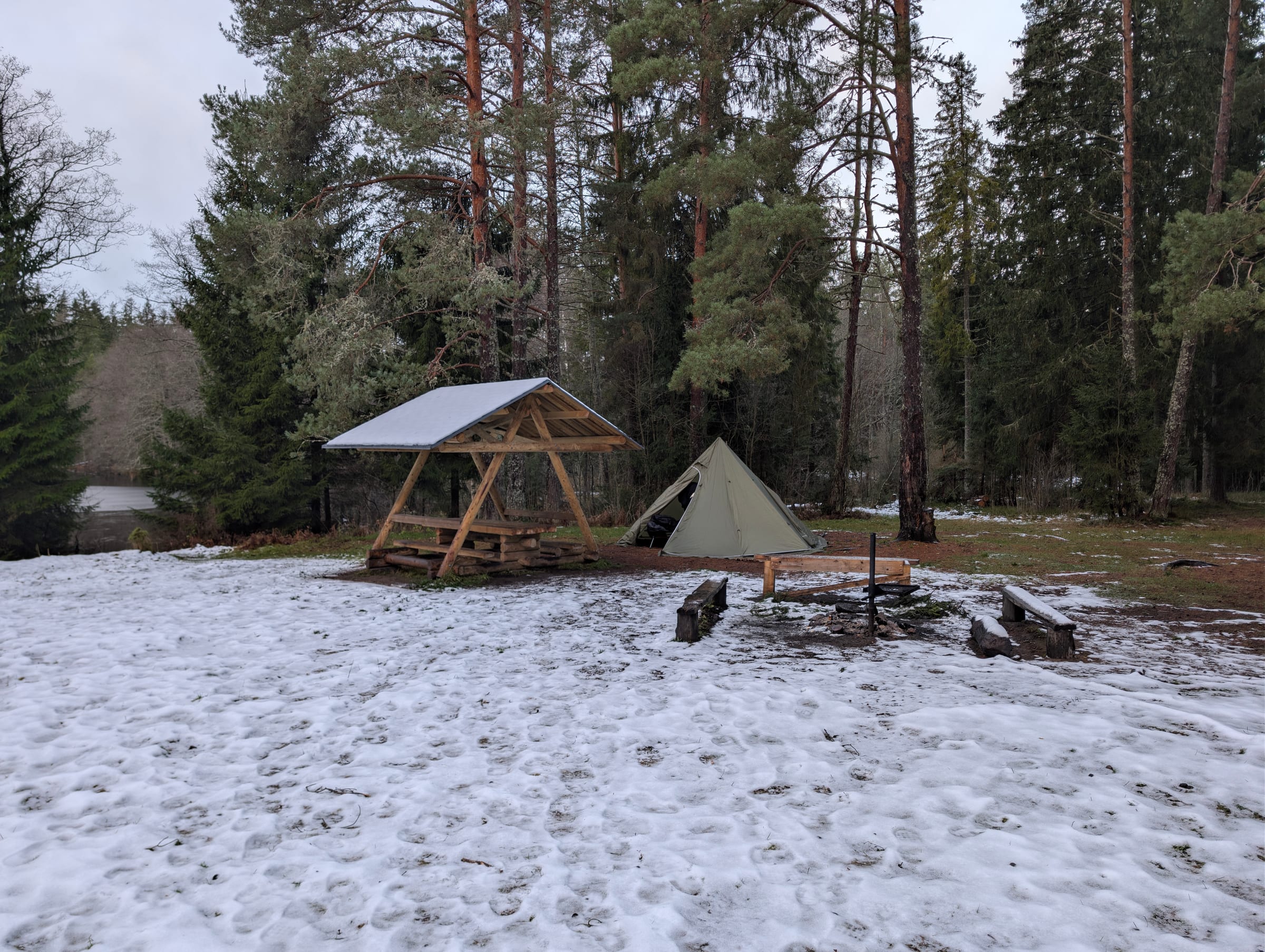 Varjualune, telk ja lõkkease hommikuses lumes